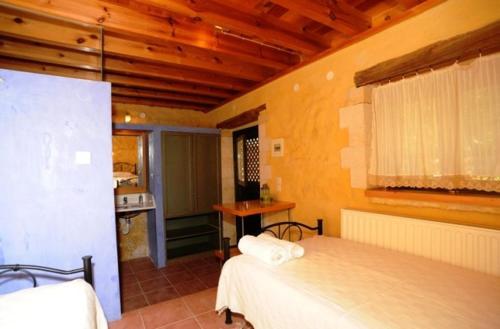 a bedroom with two beds and a kitchen in a room at Villa Alexandrou in Vamos