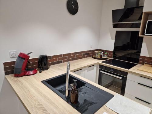 a kitchen with a sink and a stove at L'instant cosy, t2 bourg de Royat in Royat