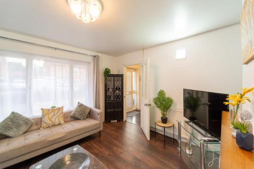 a living room with a couch and a flat screen tv at Stylish 4 Bed Henbury Home with Free Parking in Bristol