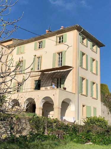 - un bâtiment sur une colline avec une personne sur un balcon dans l'établissement Bastide de charme - Les Arcades, à Sablet