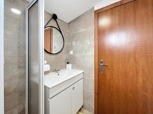 a bathroom with a sink and a wooden door at Dinos Sea View in Machico