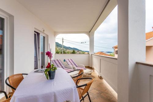 a balcony with a table and chairs and a window at Apartments Nada in Banjol