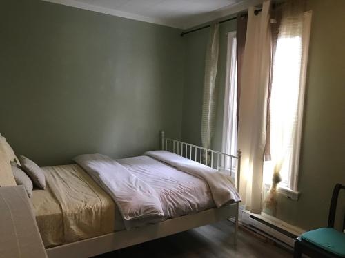 a bedroom with a bed and a window at Victorian2 Henderson Héritage Home in Ottawa