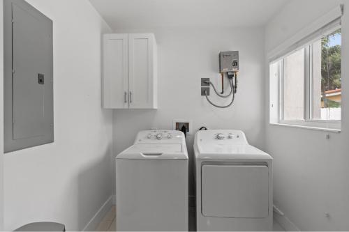 a white kitchen with two sinks and a window at Miami Japandi Style Pool - BBQ in Miami
