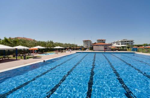 a large swimming pool with blue water at Residence Nova Marina in Sottomarina