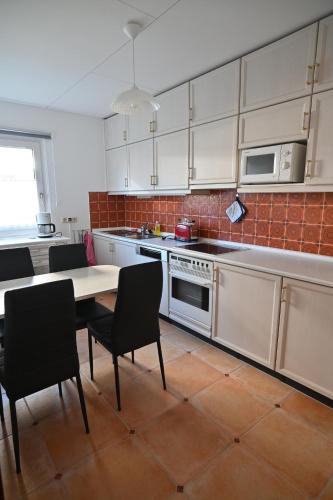 a kitchen with white cabinets and a table and chairs at Ferien-Bungalow Wiesenweg in Timmendorfer Strand