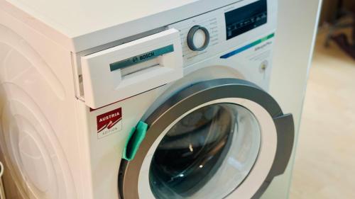 a white washing machine sitting in a room at CK Apartment in Oberhofen am Irrsee