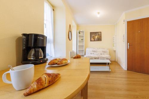 een keuken met een tafel met croissants en een koffiezetapparaat bij La Terrasse de Chamalières - Central - Wifi in Chamalières