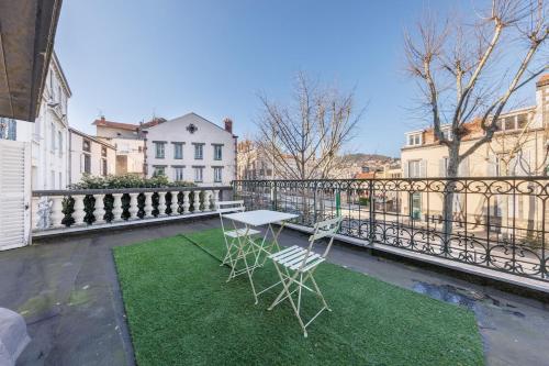 een tafel en twee stoelen op een balkon bij La Terrasse de Chamalières - Central - Wifi in Chamalières