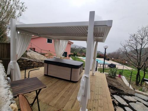 a pergola on a deck with a table and a bench at VILLA ROSA in Piazza