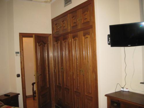 a room with a large wooden door and a television at Hostal Granada in Salamanca