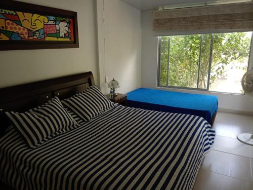 ein Schlafzimmer mit einem Bett und einem Fenster in der Unterkunft Villa Mariela in Villeta