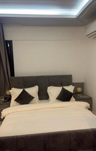 a large bed with black and white pillows at Scarlett Apartments in Monrovia