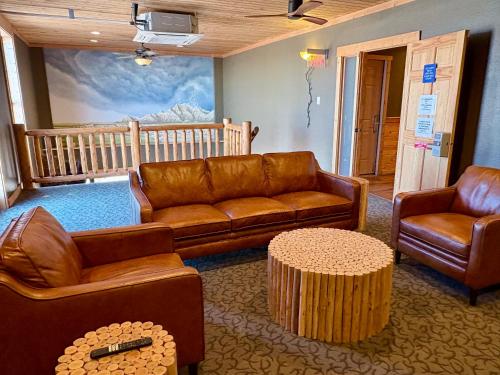 a living room with leather couches and a table at Americas Best Value Inn Wall in Wall