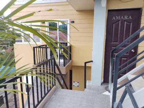 a black door on a house with a staircase at Amara Transient House - Homestay in Baguio