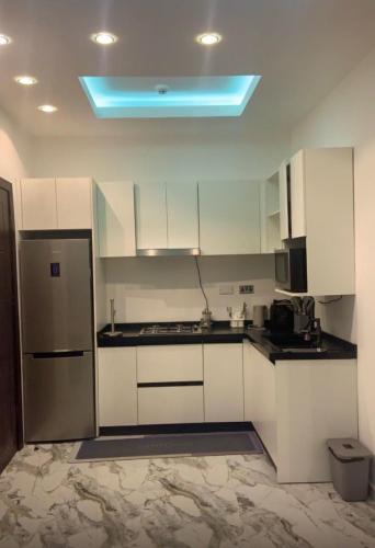 a kitchen with white cabinets and a blue light at Scarlett Apartments in Monrovia