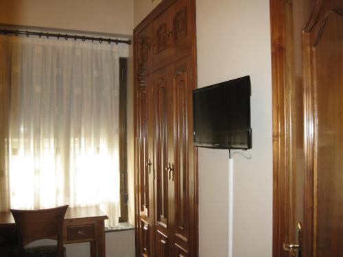 a room with a flat screen tv on a wall at Hostal Granada in Salamanca