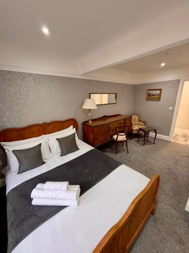 a bedroom with a large bed and a desk at Juniper Berry in Southampton