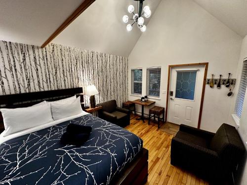 Un dormitorio con una cama, una silla y una mesa. en Cozy Cabin Centrally Located Close To Walking Trails And Beaches!, en Ucluelet