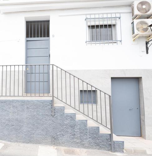 a white house with a door and stairs at La casita de elle in Alora