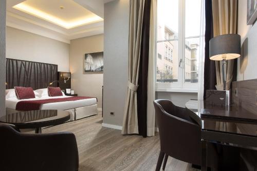 Cette chambre comprend un lit et un bureau. dans l'établissement Hotel Artemide, à Rome