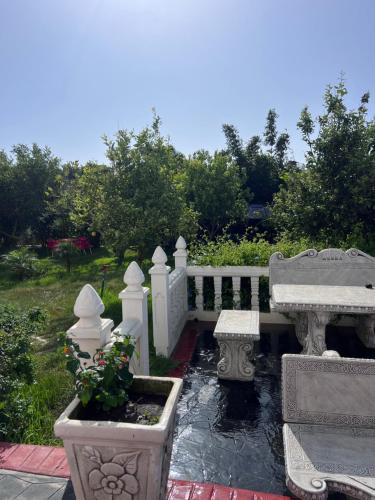 a garden with a white bench and some plants at Charmante Villa à Rmilat Plage in Asilah