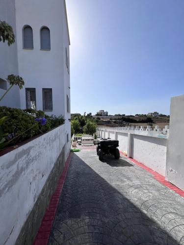 a car parked on a street next to a building at Charmante Villa à Rmilat Plage in Asilah