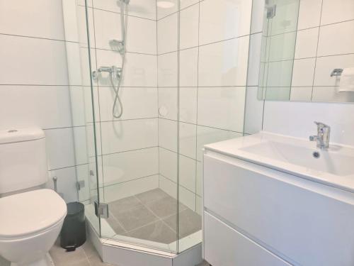a bathroom with a shower and a toilet and a sink at Little Coogee Hotel in Sydney
