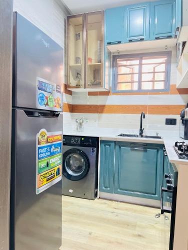 a kitchen with a refrigerator and a washing machine at Majestic Oasis in Lagos