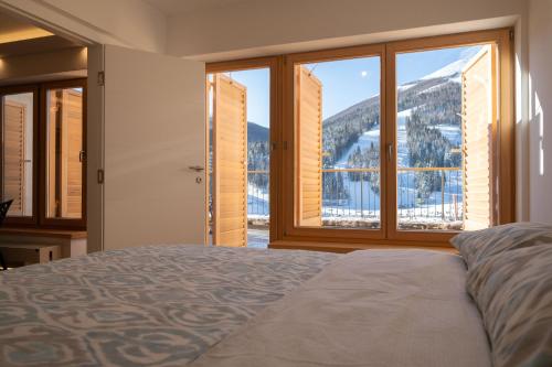 a bedroom with a bed and a large window at Bjelasnica Mountain Retreat in Bjelašnica