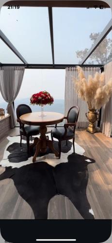 a dining room with a table and chairs and a window at Morada valente in Gramado
