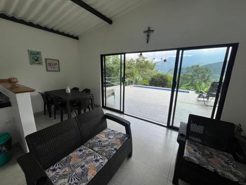 a living room with a couch and a view of a patio at " Paraíso Privado en Sasaima " Finca Exclusiva Solo para Ti " Un lugar secreto para descansar con privacidad al 100 in Sasaima