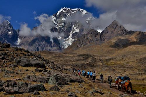 a group of people walking on a mountain trail at Casa Cóndor Ausangate in Tinke