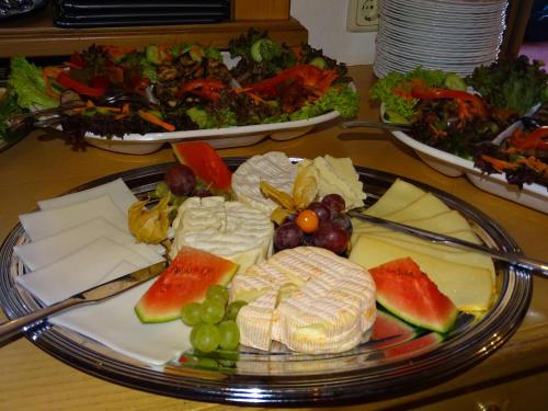 a plate of cheese and fruit on a table at Hotel und Restaurant Piccolo in Thale
