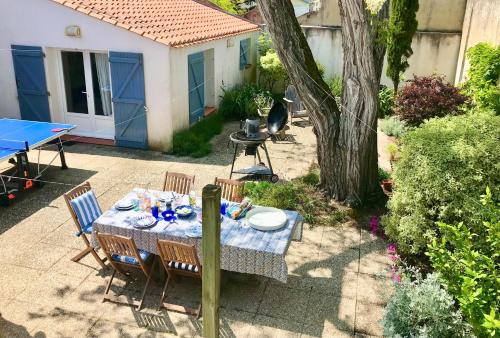 une table et des chaises dans une cour avec une table et un arbre dans l'établissement Villa 