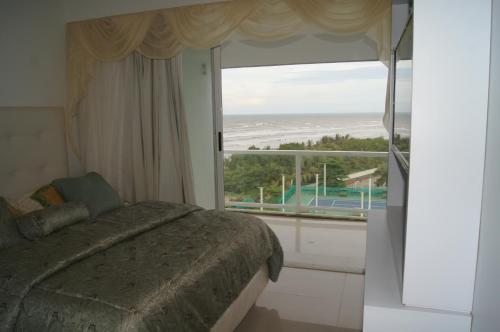 HigueroteにあるHiguerote Luxury Vacation Beachのベッドがあり海が見える寝室