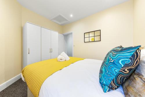 a bedroom with a large bed with a yellow blanket at Spacious London 2-Bed Flat with a King Bed-Save on Long Stays-5 Separate Beds- Parking Available! in Barnet