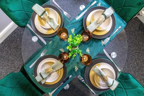 a table with four plates on top at Spacious London 2-Bed Flat with a King Bed-Save on Long Stays-5 Separate Beds- Parking Available! in Barnet