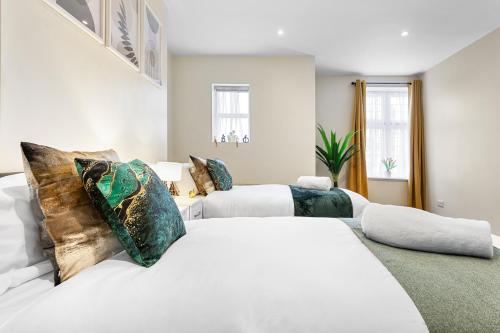 a white bedroom with two beds and a couch at Spacious London 2-Bed Flat with a King Bed-Save on Long Stays-5 Separate Beds- Parking Available! in Barnet
