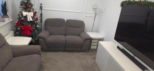 a living room with two chairs and a christmas tree at Sophia's place in Wolverhampton