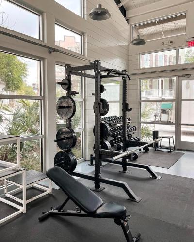 a gym with several tread machines in a room with windows at The Paramour comfy home with ground floor bedroom and fenced in yard in Summerville
