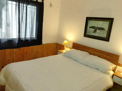 Un dormitorio con una cama blanca y una ventana. en La Guido 3 sin operar, en Viedma