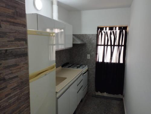 Una cocina con gabinetes blancos y un horno de estufa. en La Guido 3 sin operar, en Viedma