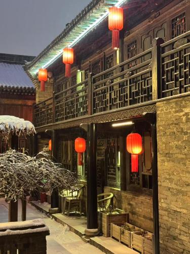 a building with red lanterns on the side of it at Elsewhere Hotel The former residence of the draft bank in Pingyao