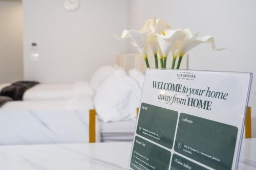 a sign on a table with flowers in a room at Downtown Center Silverstone Tower I and II Long-Term Booking Only Your second home in Vancouver in Vancouver