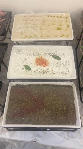 three trays of food sitting on top of a refrigerator at Jordan View Hotel in Amman