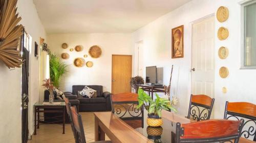 Una sala de estar con un sofá, una mesa y sillas. en Sayaná House, en Temixco
