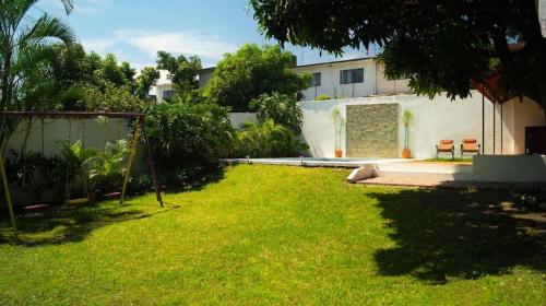 un patio con un edificio y un césped verde en Sayaná House, en Temixco