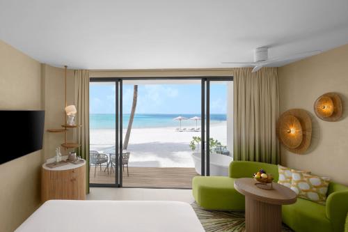 a living room with a view of the beach at Centara Mirage Lagoon Maldives in Nakachchafushi