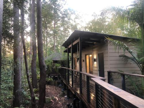 a small house in the woods with a wooden porch at Earthly Retreat - Private Noosa Hinterland Getaway in Doonan